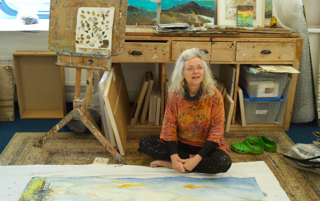 Frances Hatch sitting on the floor of her studio beside a work in progress.